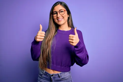 A woman wears a purple sweater